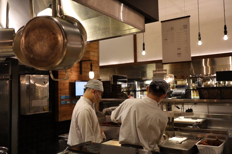 Mod Pizza team members working together in a friendly kitchen environment